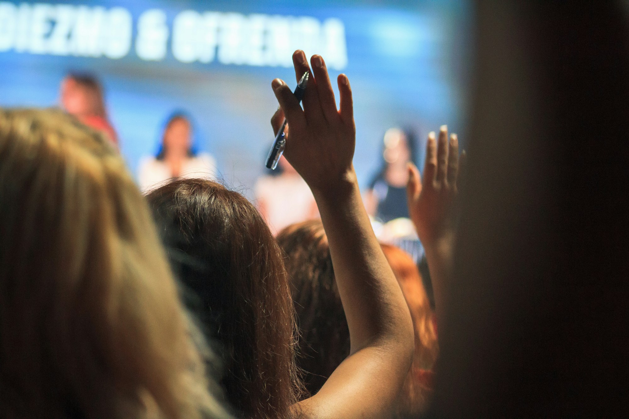 An audience with hands raised
